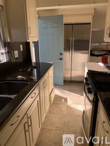 A kitchen with a black counter top and a blue door.
