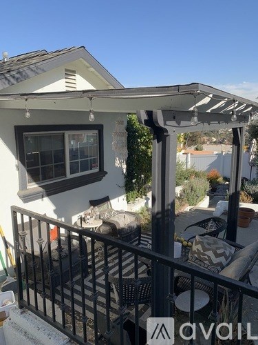 A patio with a table and chairs under a pergola.