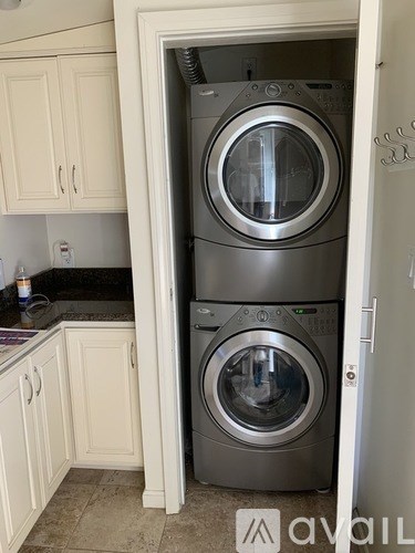 A stack of two washing machines in a kitchen.