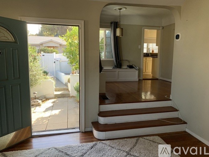 A hallway with a staircase leading to a bedroom.