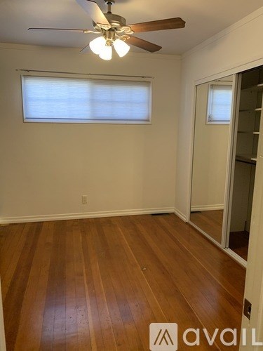 A room with wooden floors and a ceiling fan.