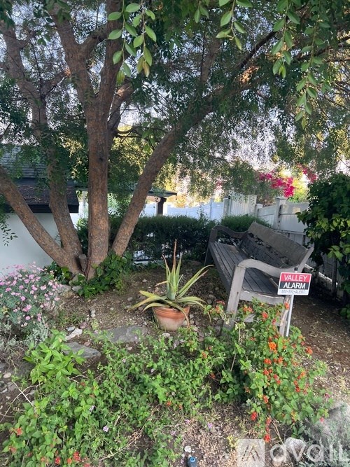 A garden with a bench and a sign that says "WALKY ALARM".