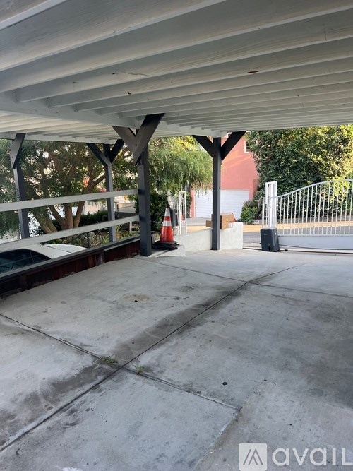 A concrete area with a white roof and a fence in the background.
