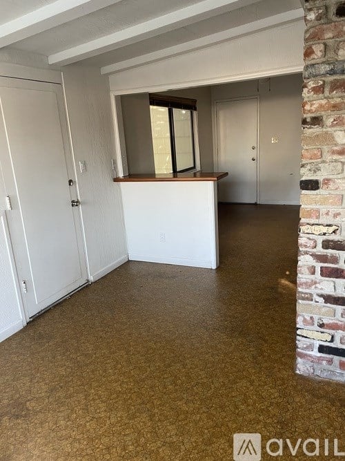 A room with a brick column and a window.