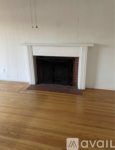 A white fireplace with a black fire place.
