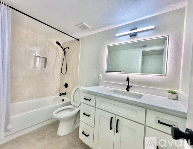 A bathroom with a white toilet, sink, and a mirror.