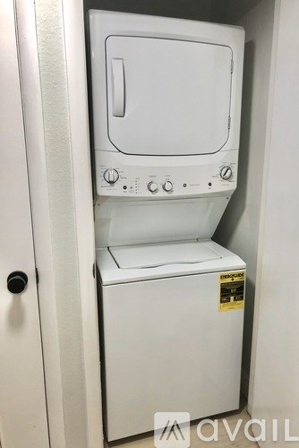 A white dryer is sitting in a white door.