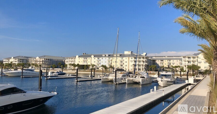 A marina with boats docked and buildings in the background.