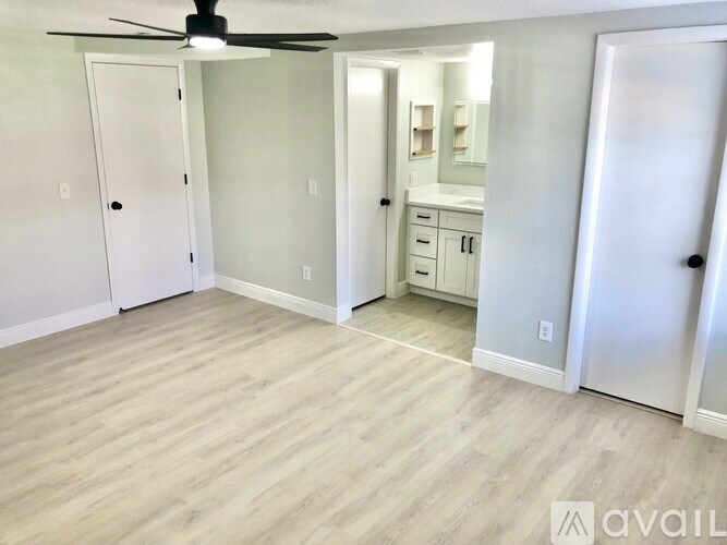 A room with a ceiling fan and wooden flooring.