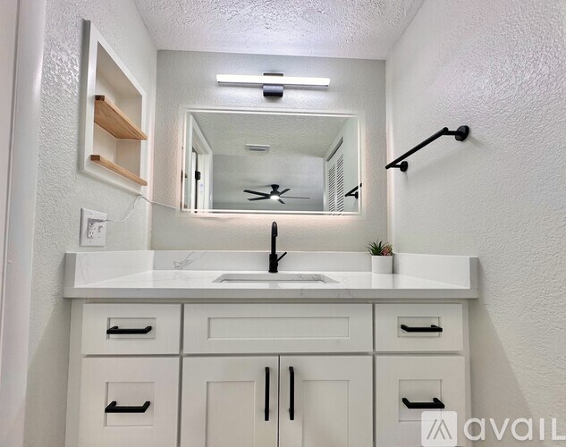 A bathroom with a white sink and a mirror above it.