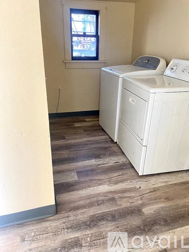A white washing machine sits in a room with a window.