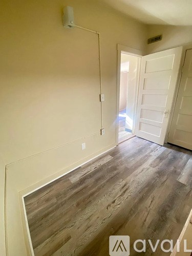 A room with wooden flooring and a white door.