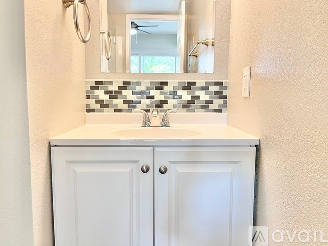 A bathroom with a white sink and a mirror above it.