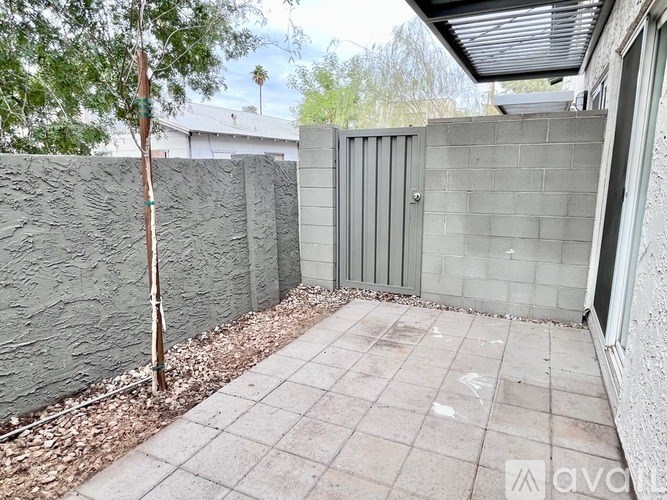 A concrete fence and wall with a tree in front of it.