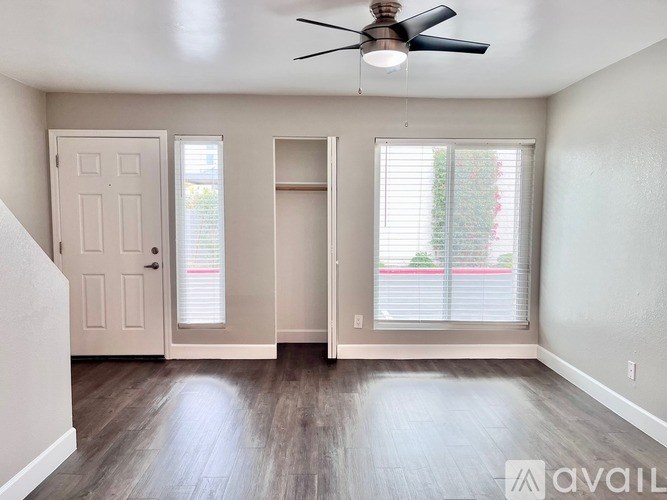 A room with a ceiling fan and a door leading to a balcony.