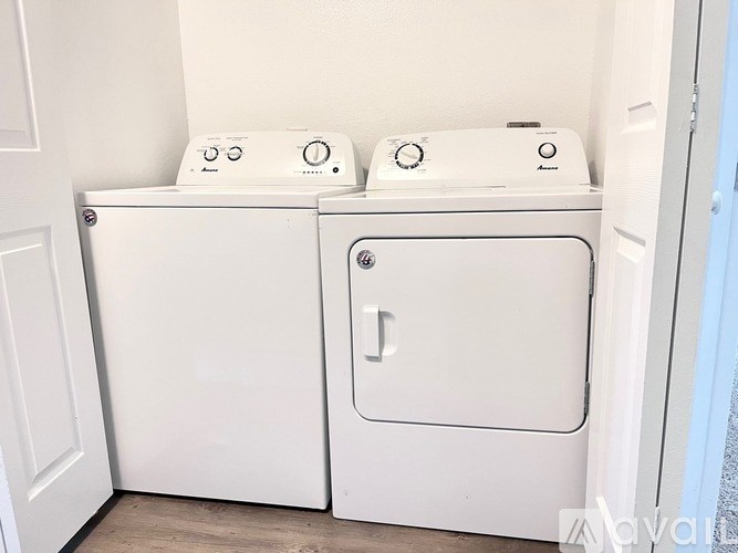A white washing machine and dryer in a small laundry room.