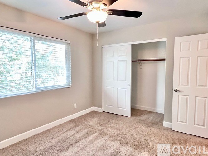 A room with a ceiling fan and two doors.