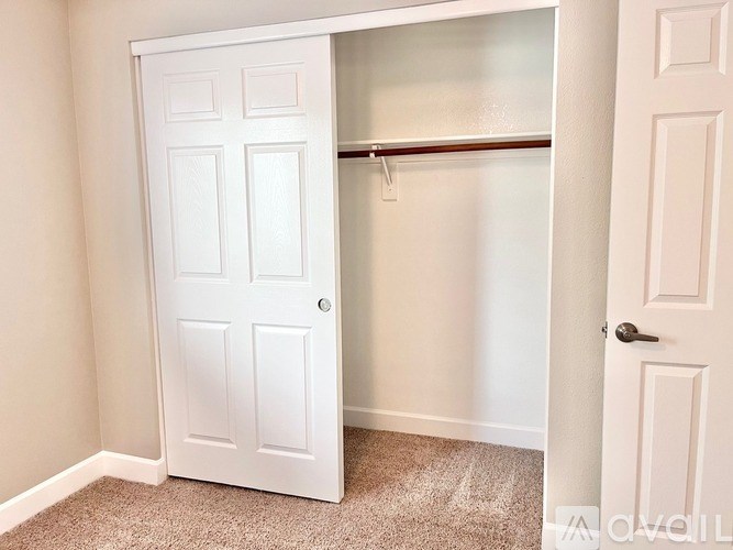 A white door is open to a room with a carpeted floor.