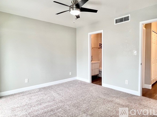 A room with a ceiling fan and a carpeted floor.