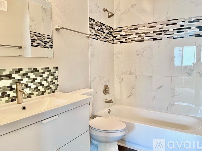 A white bathroom with a marble tile shower.