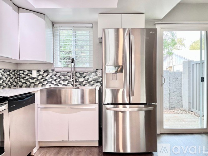 A kitchen with a stainless steel refrigerator and a black dishwasher.
