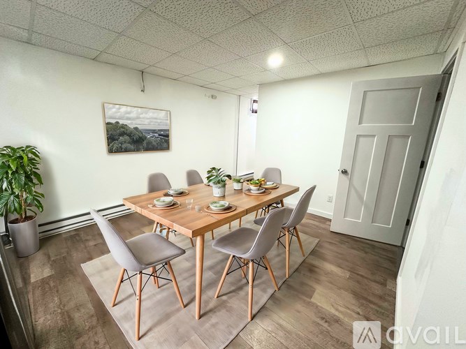 A dining room with a wooden table and chairs.