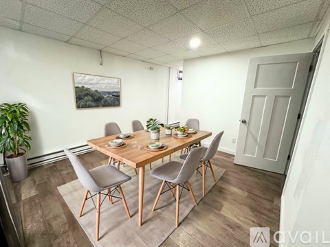 A dining room with a wooden table and chairs.