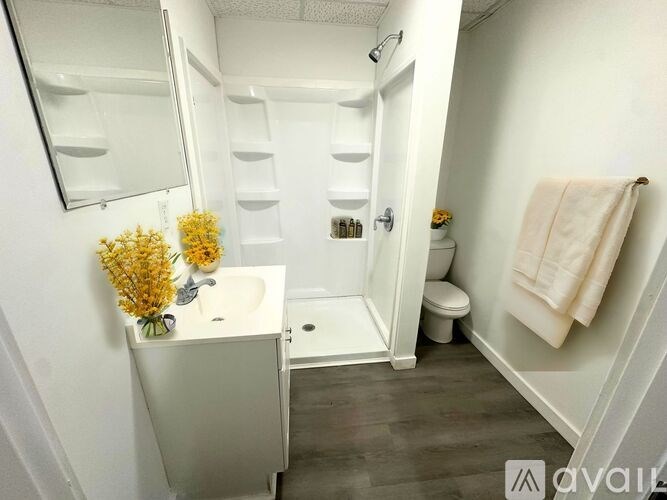 A small white bathroom with a toilet, sink, and mirror.