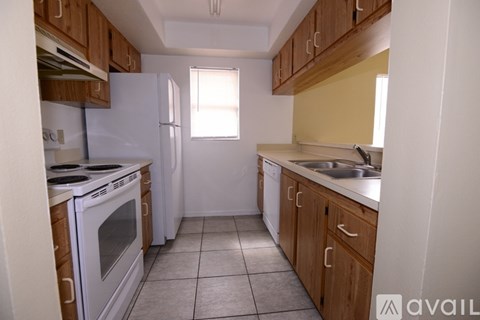 A kitchen with white appliances and wooden cabinets.