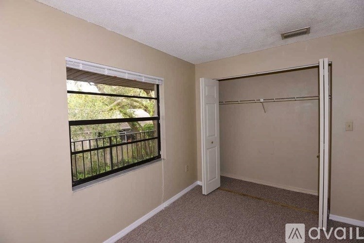 A room with a window and a closet.