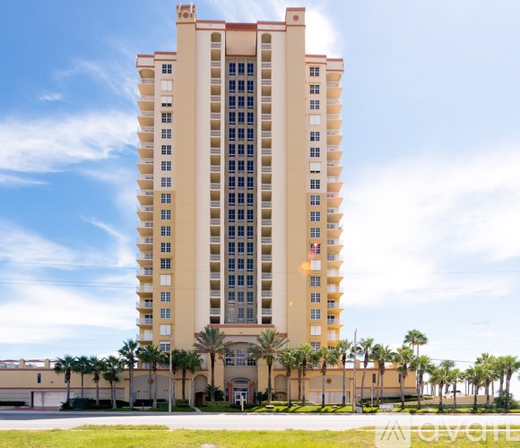 A tall building with a red roof and a blue sky in the background.