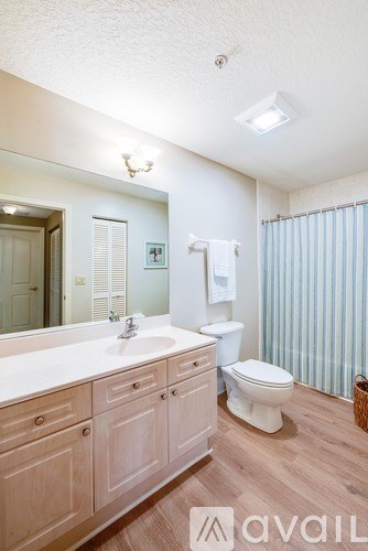 A bathroom with wooden cabinets and a white sink.