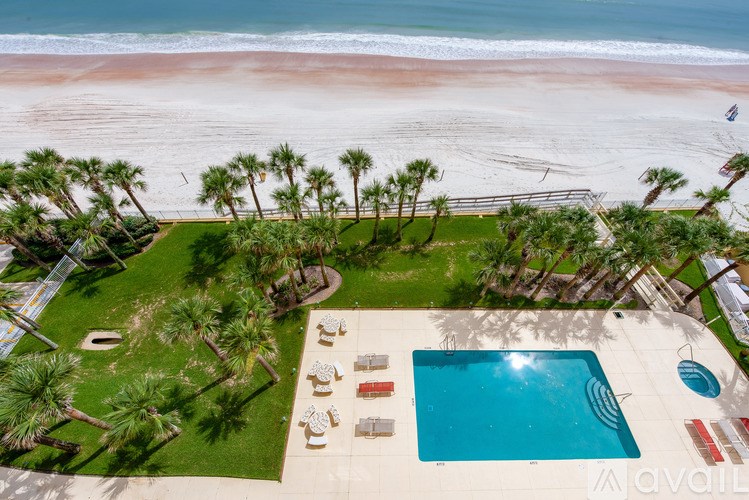 A beachfront property with a pool and palm trees.