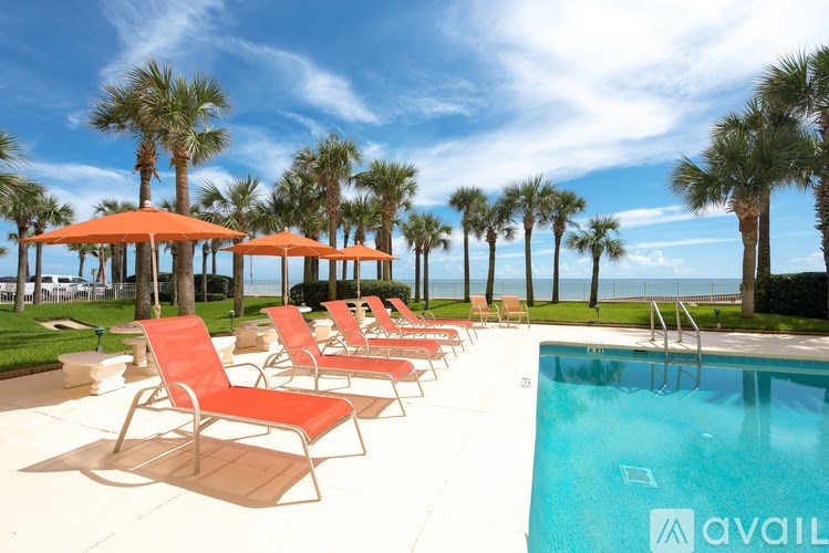 A pool area with chairs and umbrellas is available for use.