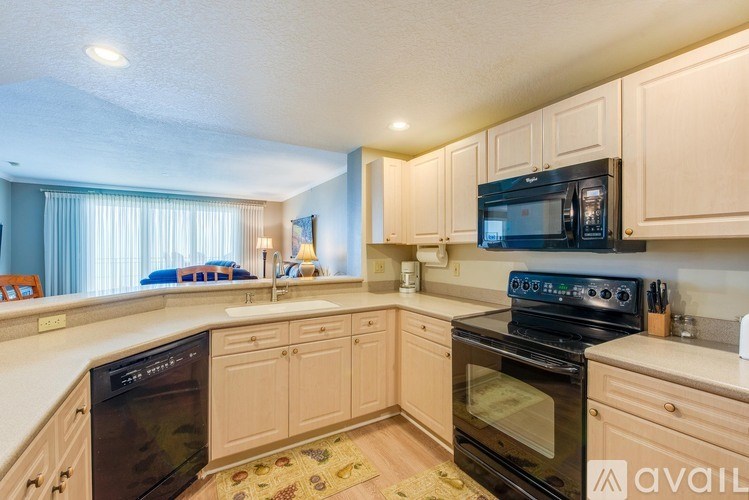 A kitchen with wooden cabinets and black appliances.