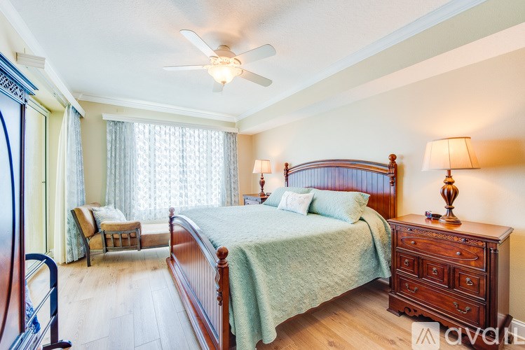 A bedroom with a bed, dresser, and chair.