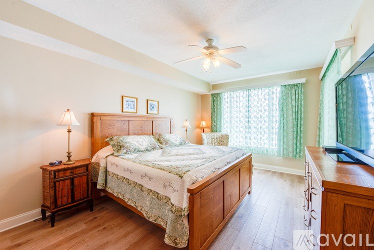 A bedroom with a bed, nightstand, and window.