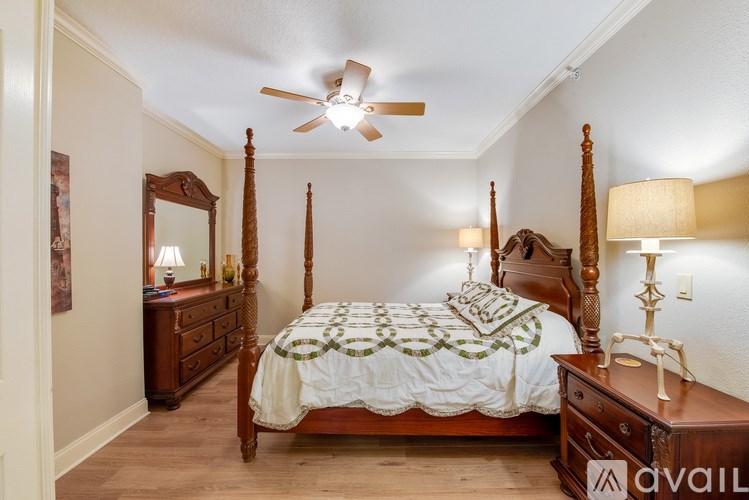 A bedroom with a four poster bed and a ceiling fan.