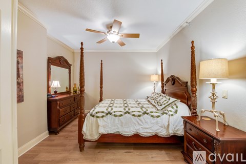 A bedroom with a four poster bed and a ceiling fan.