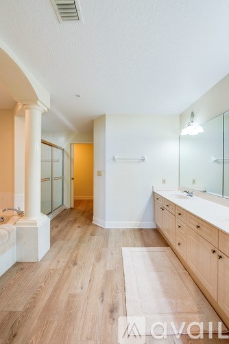 A bathroom with a tub, sink, and mirror.