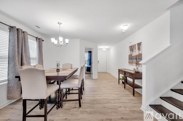 A dining room with a wooden table and chairs.