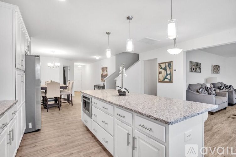 A kitchen with white cabinets and a granite countertop.