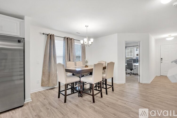 A kitchen with a dining table and chairs.