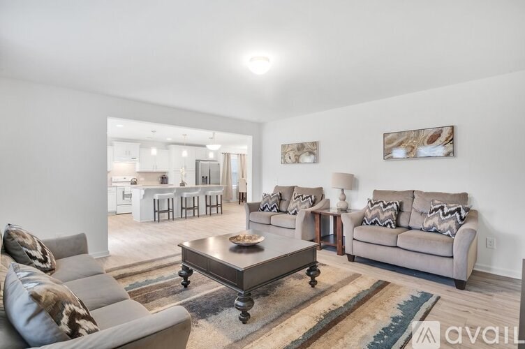 A living room with a grey couch, a coffee table, and a rug.