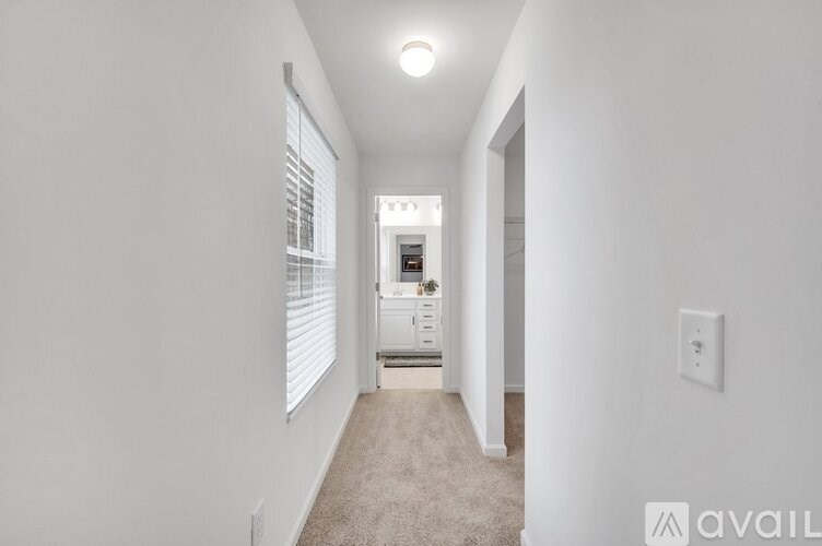 A long hallway with a light on the ceiling and a door on the right.