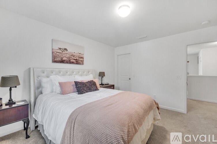 A bedroom with a large bed and a painting on the wall.