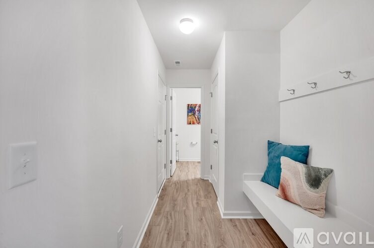 A hallway with a bench and a door at the end.