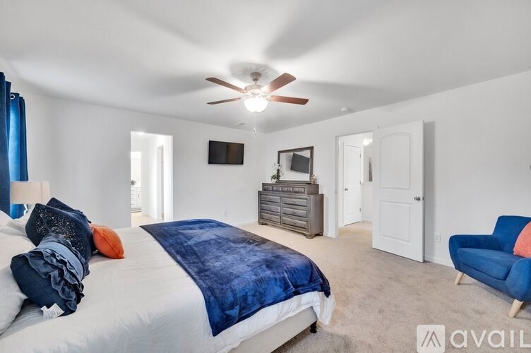 A bedroom with a large bed and a blue chair.