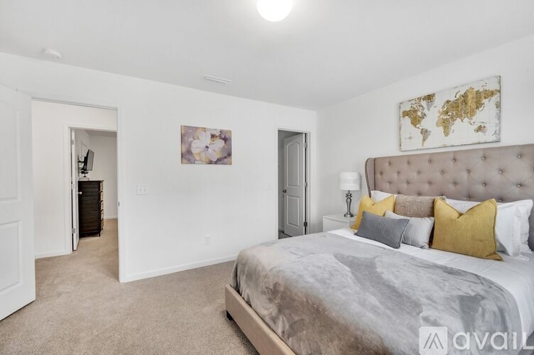 A bedroom with a large bed and a painting on the wall.