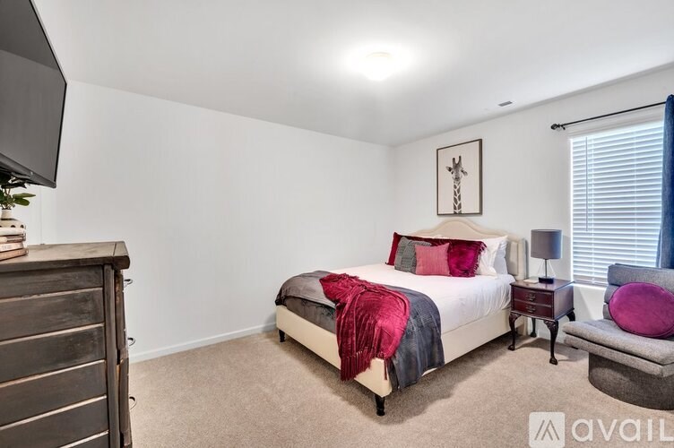 A bedroom with a bed, nightstand, and chair.